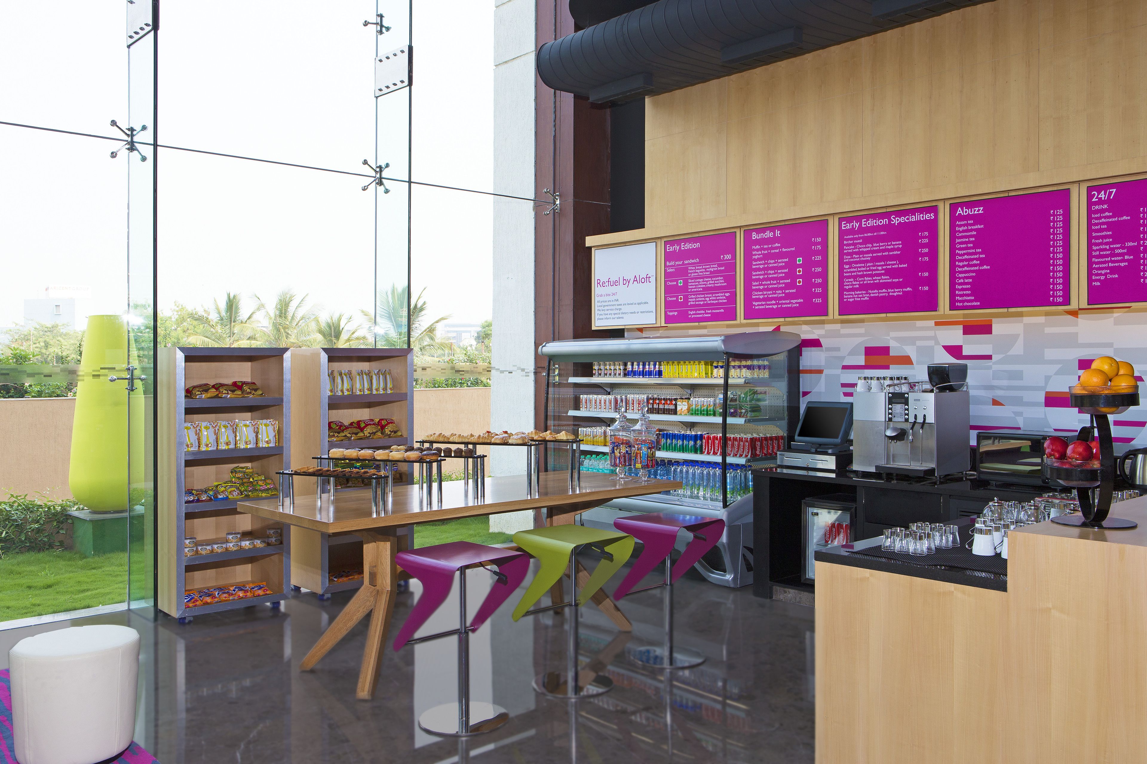 Een modern café met een houten toonbank, kleurrijke krukken en een menubord.