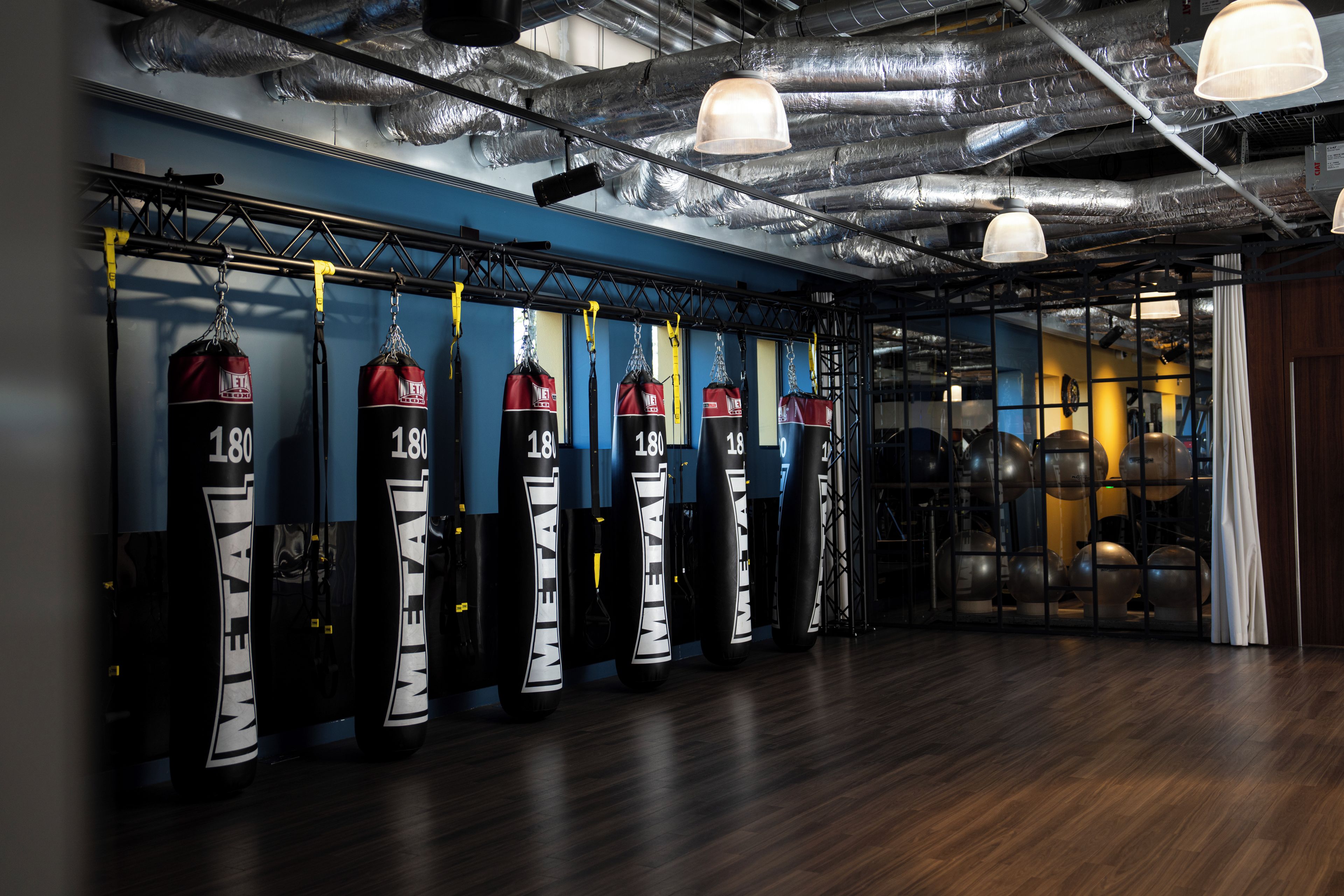 Un gimnasio con sacos de boxeo y equipo de ejercicio.