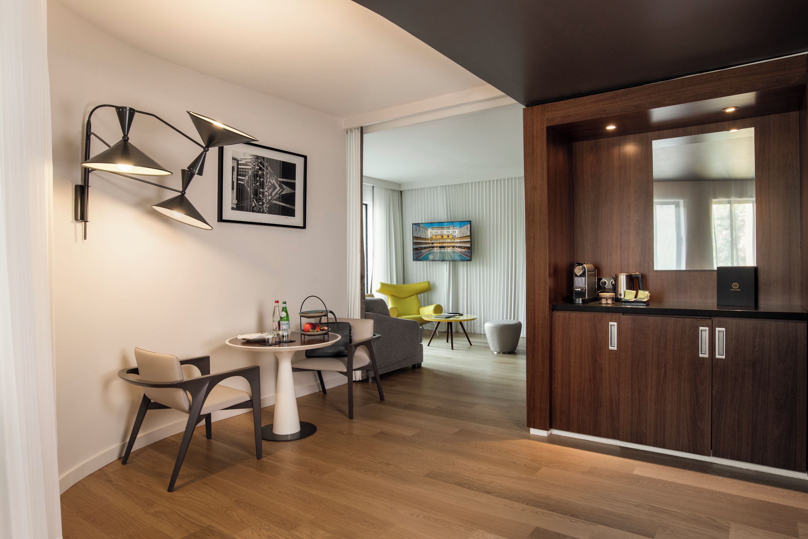 Ein modernes Hotelzimmer mit Essbereich, einer Küche und einem Wohnbereich.
