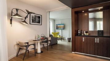 Ein modernes Hotelzimmer mit Essbereich, einer Küche und einem Wohnbereich.