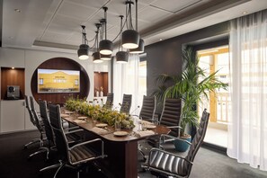 A conference room with a long table, chairs, a projector screen, and a potted plant. - Molitor Hotel & Spa Paris - MGallery Collection (Paris)