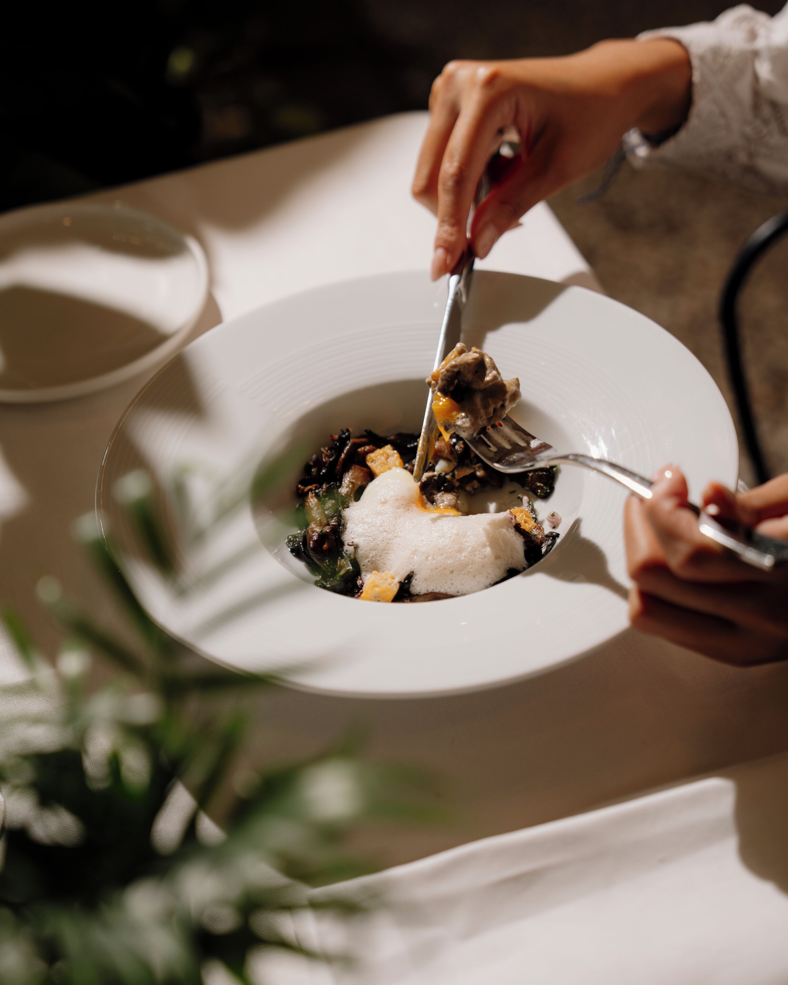 Une table à manger avec une assiette de nourriture, une fourchette et un couteau.
