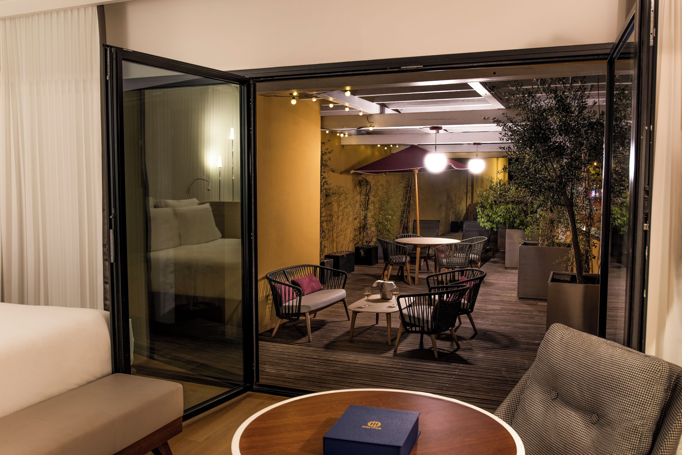 Una habitación de hotel moderna con una puerta de cristal que da a un comedor.