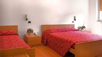 Une chambre à coucher avec deux lits en bois, une table de chevet avec une lampe et un téléphone fixé au mur.