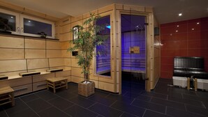 A modern bathroom with a wooden vanity, a plant, and a bathtub. - Hotel Schiller (Olching)