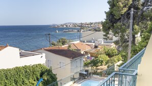 A balcony with a view of a swimming pool, a railing, and a table. - Hotel Agia Markella (Chios)