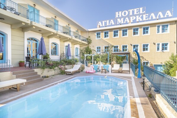 A hotel with a swimming pool, outdoor seating, and a sign reading "HOTEL ATIA MAPKELLA". - Hotel Agia Markella (Chios)
