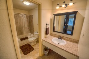 A bathroom with a sink, mirror, and toilet.
