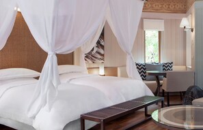 Une chambre à coucher avec un lit, un banc, une table ronde et un canapé.