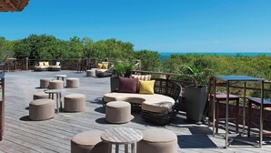 A deck with outdoor seating, including sofas and ottomans, overlooking a scenic view. - Le Domaine Deva, Series by Marriott (Bourail)