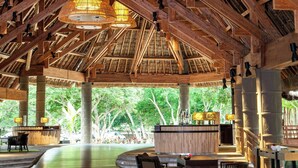 A spacious indoor area with a high wooden ceiling, multiple hanging wicker lamps, and a central reception desk. - Le Domaine Deva, Series by Marriott (Bourail)