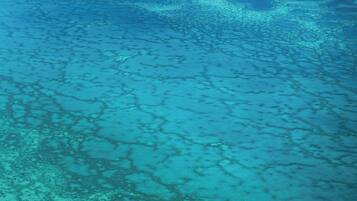 An aerial view of a coastal area with clear blue waters and visible landmasses.