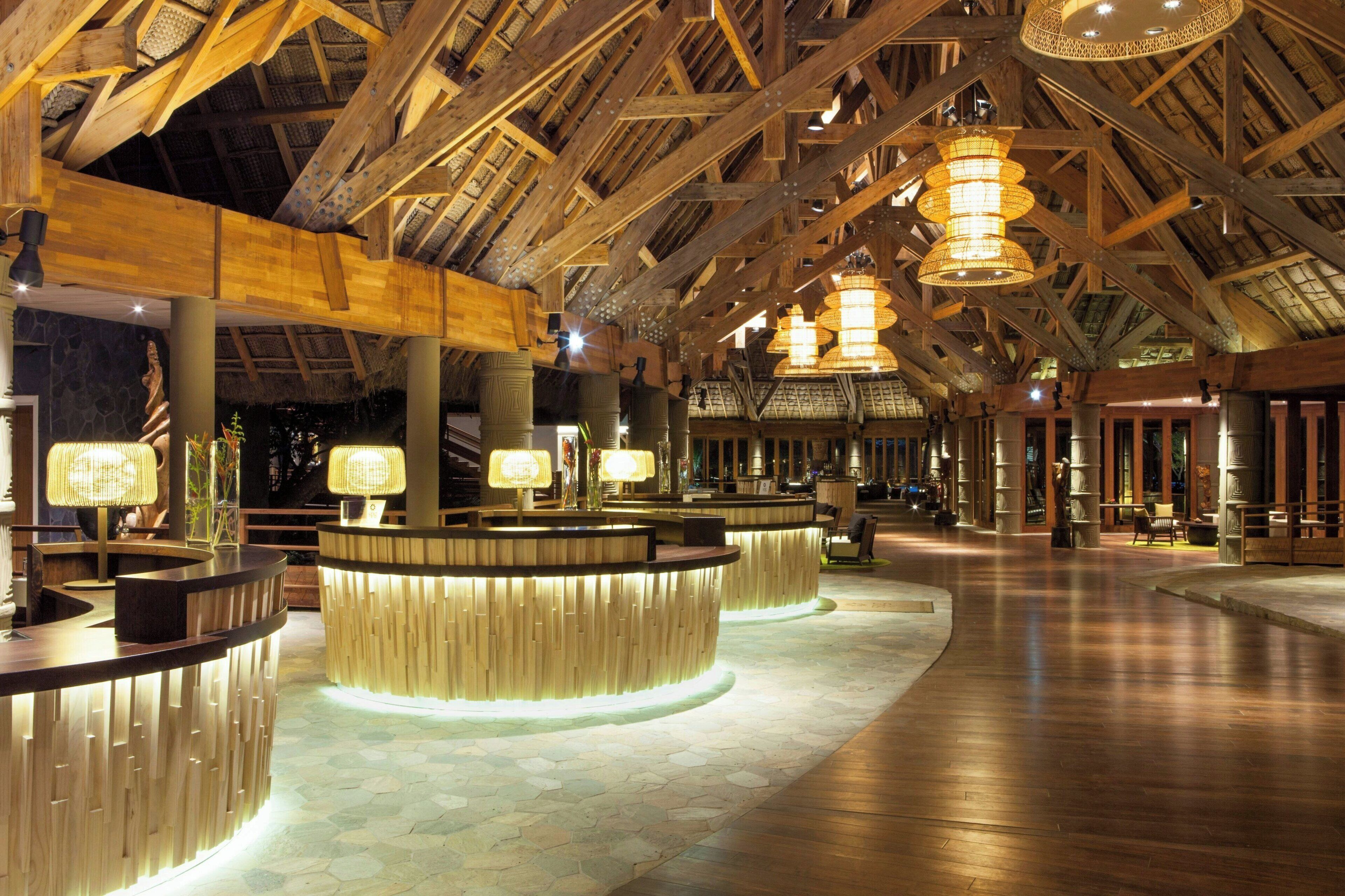 A spacious lobby with high wooden ceilings and multiple reception counters.