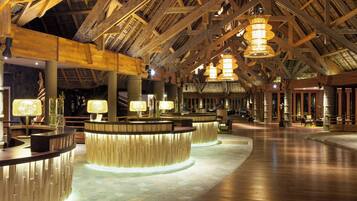 A spacious lobby with high wooden ceilings and multiple reception counters.