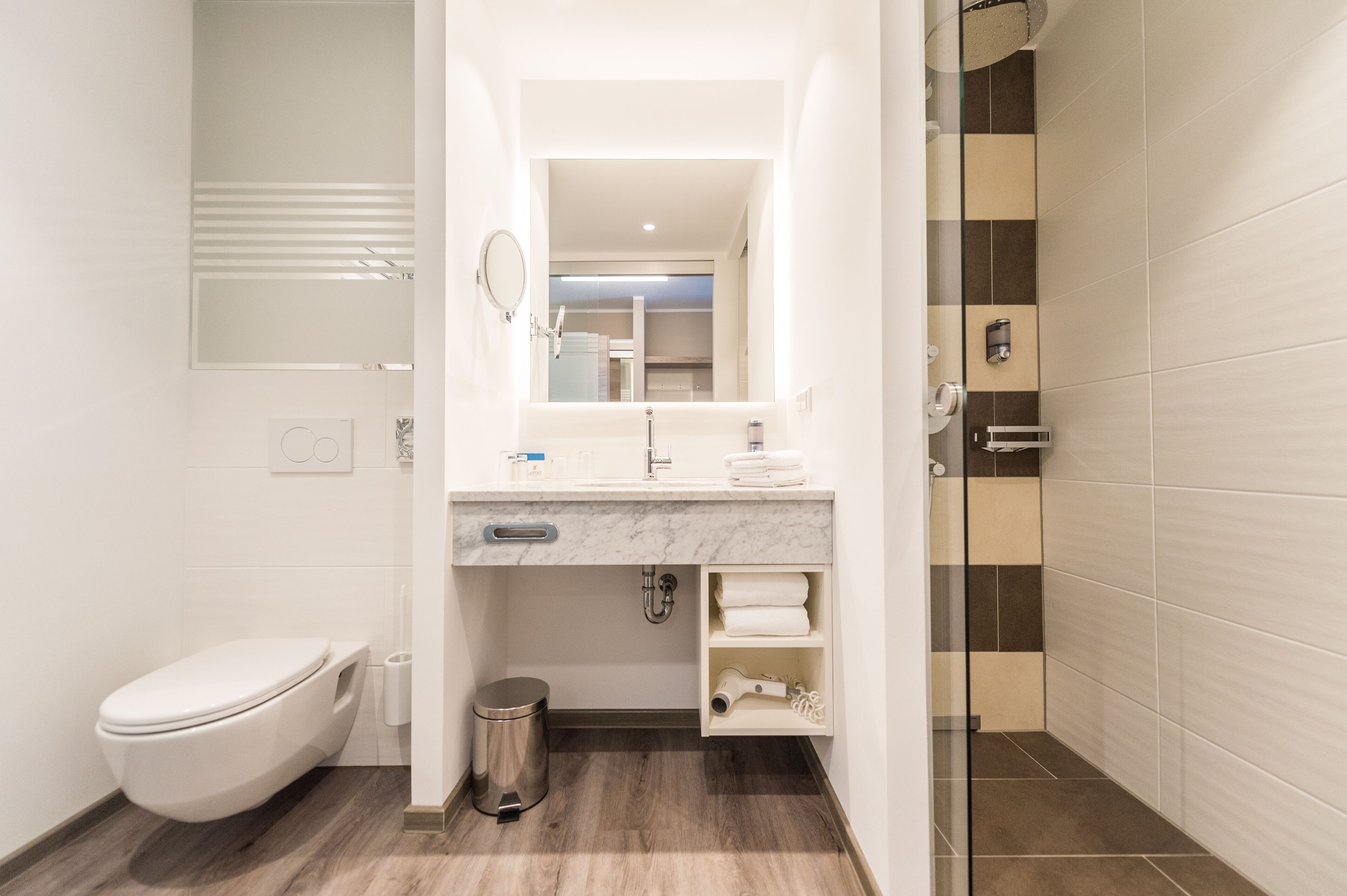 A modern bathroom with a toilet, sink, and shower area.