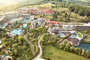 An aerial view of a resort with multiple swimming pools, a central building, and surrounding greenery. - Thermalhotel Leitner (Loipersdorf bei Fuerstenfeld)
