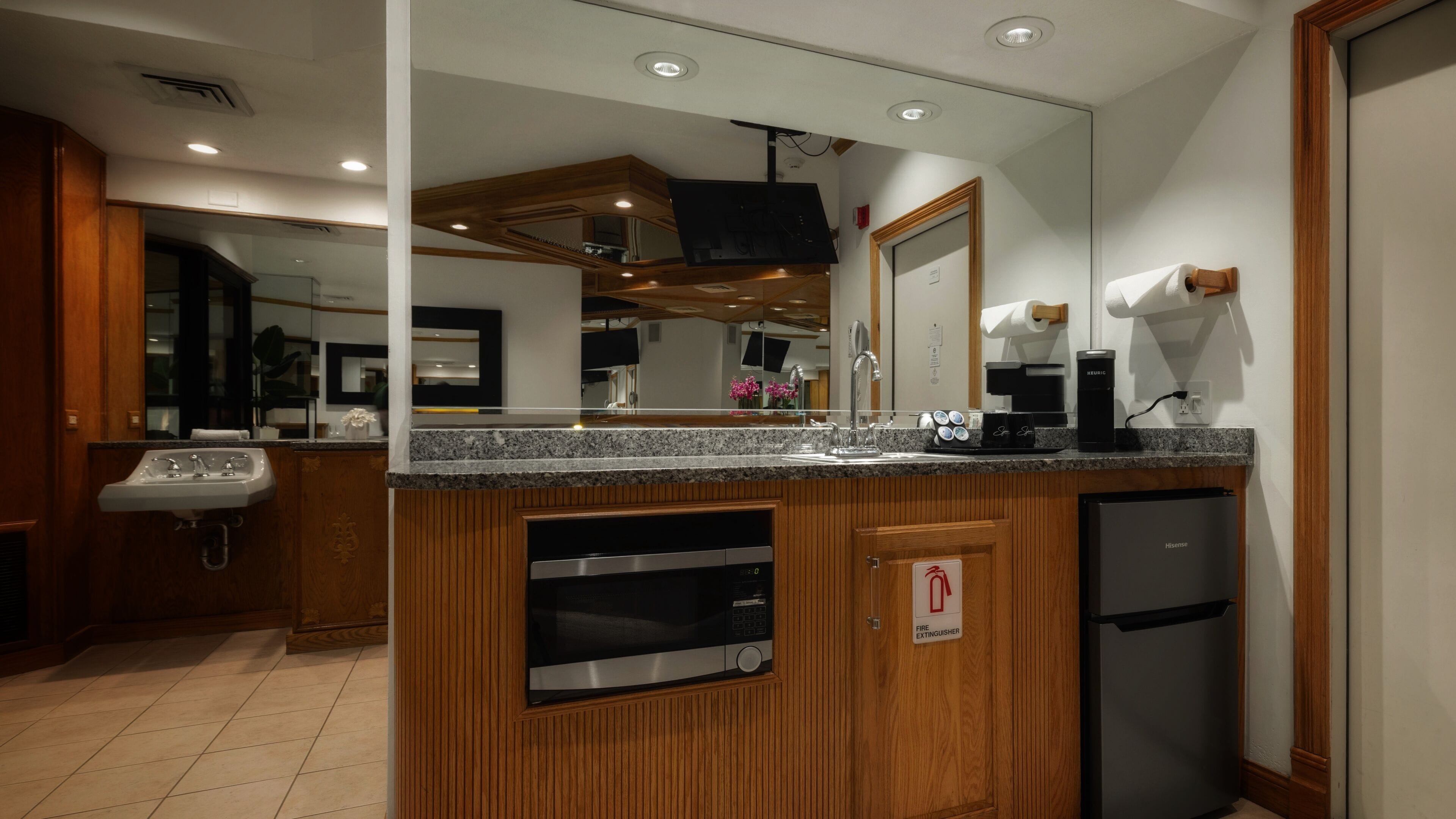 A modern kitchen with granite countertops, a built-in microwave, and a coffee maker.