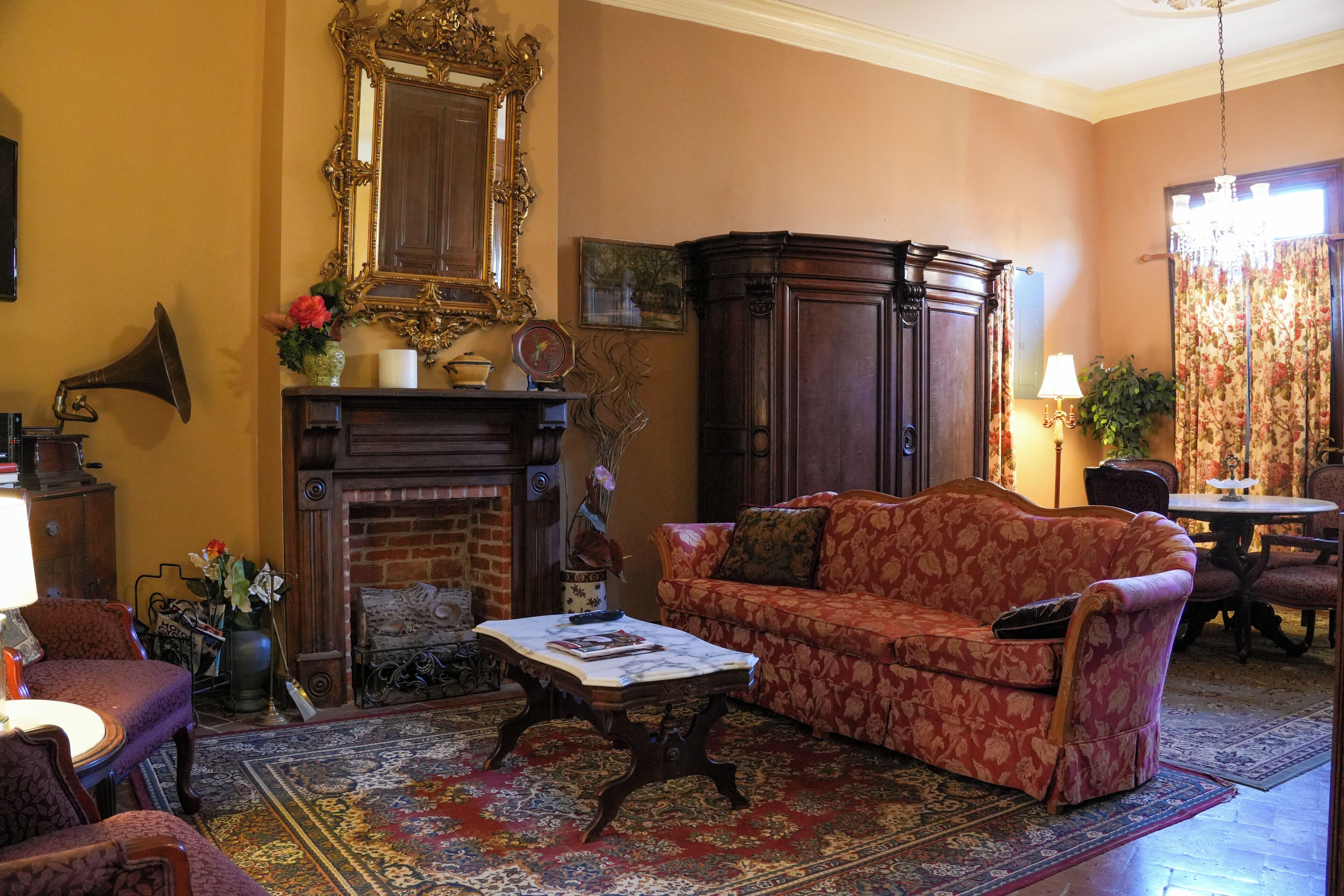 A living room with a fireplace, a sofa, a table, and a mirror.