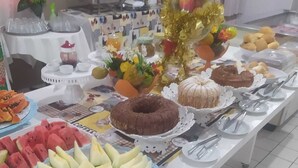 A buffet table with various food items including watermelon, cantaloupe, and a bundt cake.