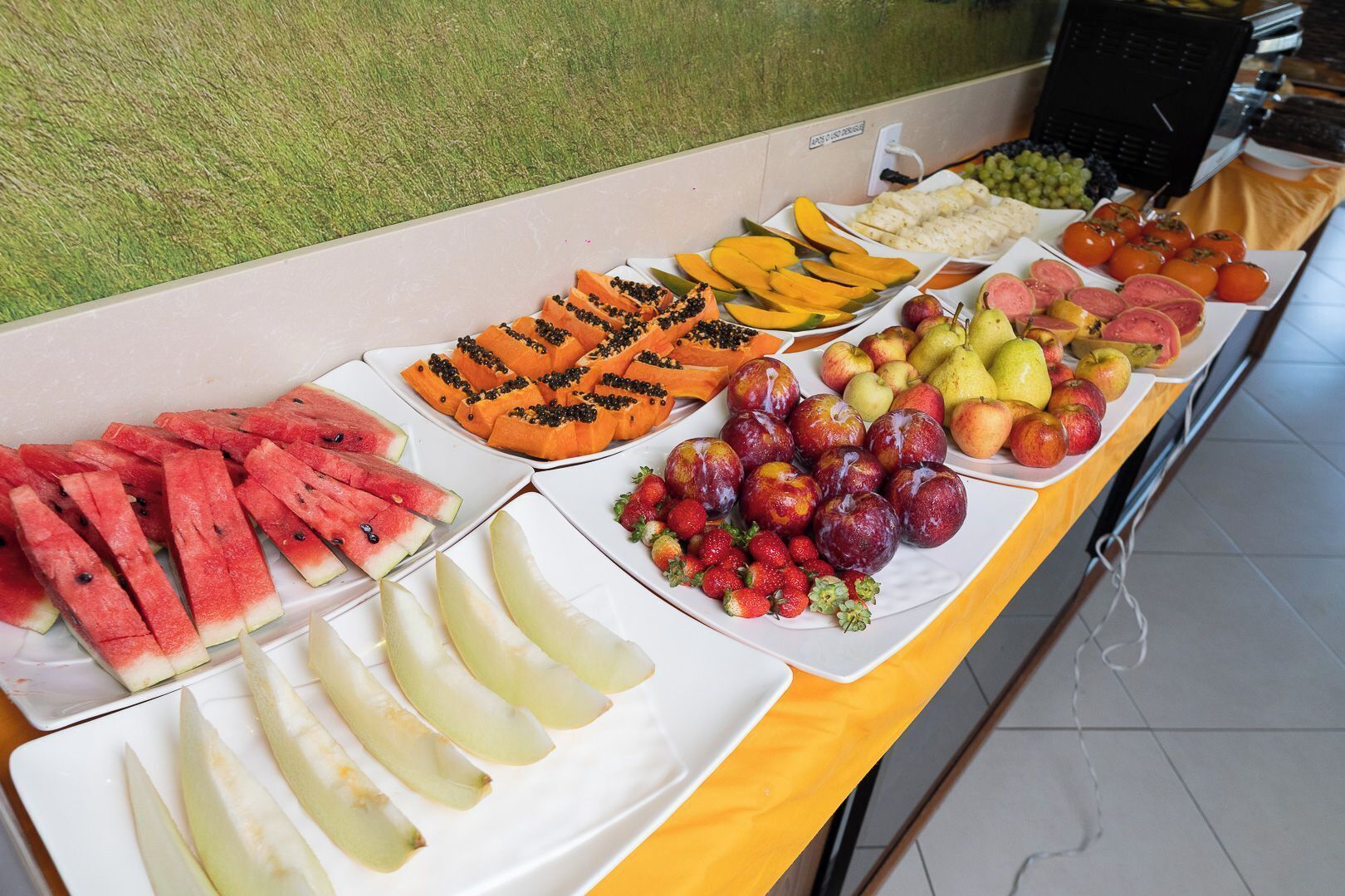 A buffet table with various fruits and vegetables.