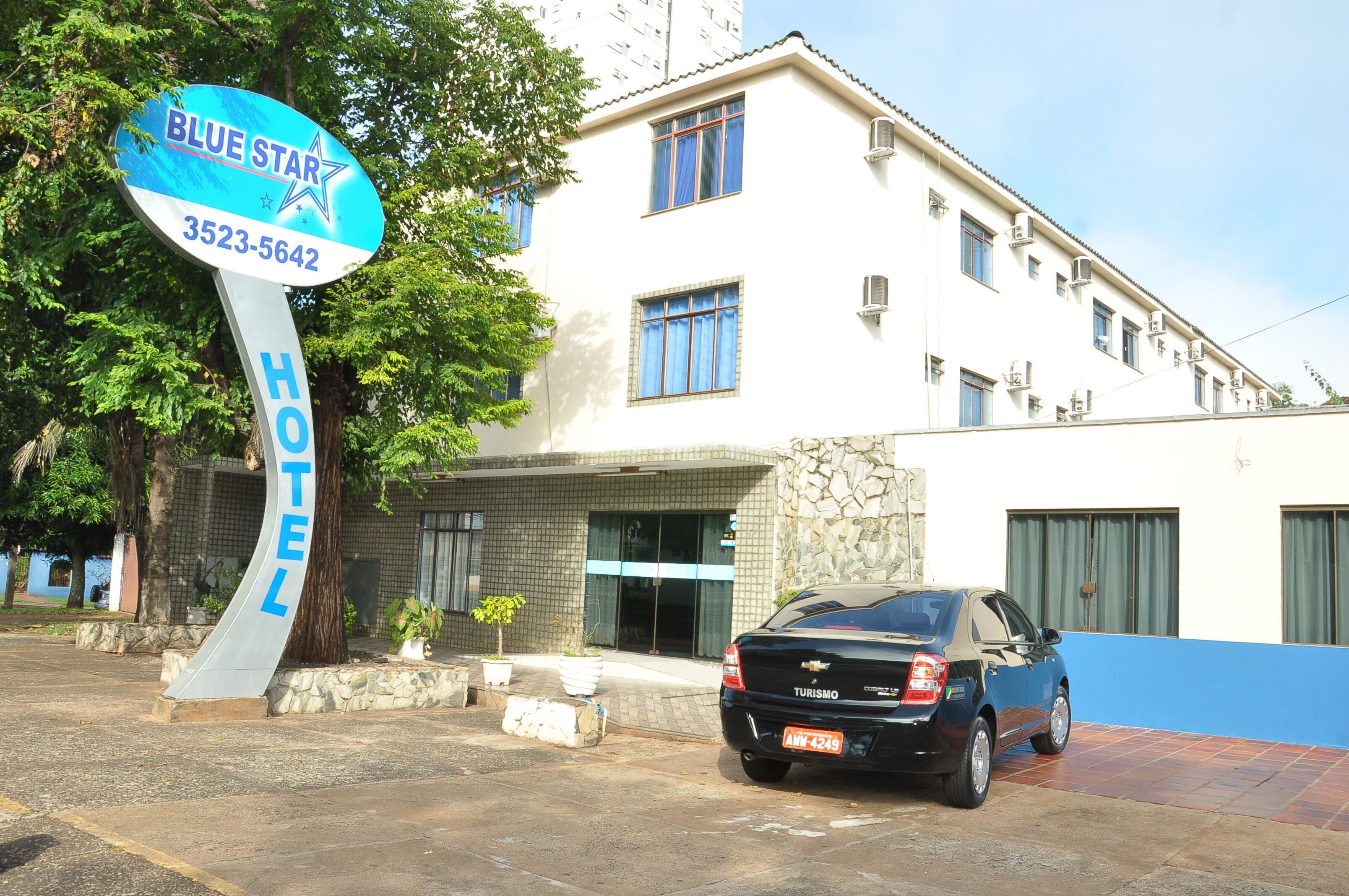 A hotel sign with a blue star and the name 'BLUE STAR HOTEL' along with a phone number.