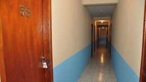 A hallway with a wooden door labeled '38' and a blue and beige wall. - Hotel Blue Star II (Foz do Iguacu)