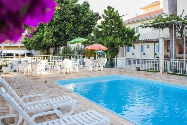 Alberca al aire libre y camastros