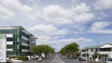 A street view with a modern building on the left and a motel on the right.