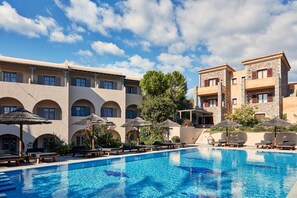 A hotel with a swimming pool, sun loungers, and umbrellas. - Angelina Aegina Boutique Escape (Aegina)