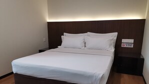 A neatly made bed with white linens in a hotel room. - Hotel Holiday (Kota Kinabalu)