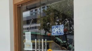 A glass door with a 'YES, Welcome Open' sign, a 'PUSI' sticker, and a metal handle. - Hotel Holiday (Kota Kinabalu)