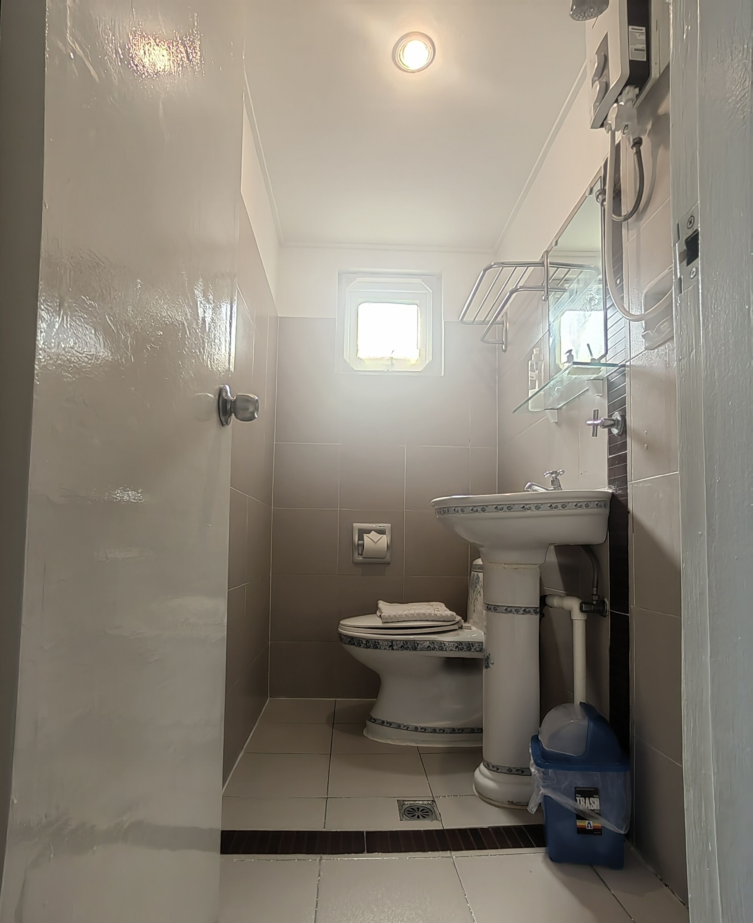 Une petite salle de bain comprenant des toilettes, un lavabo et un espace douche.