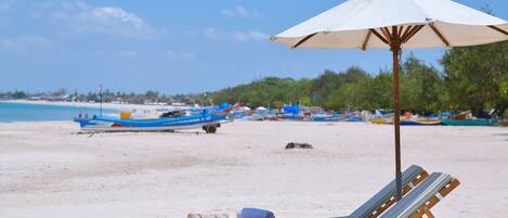Una spiaggia nelle vicinanze, sabbia bianca, lettini da mare, ombrelloni