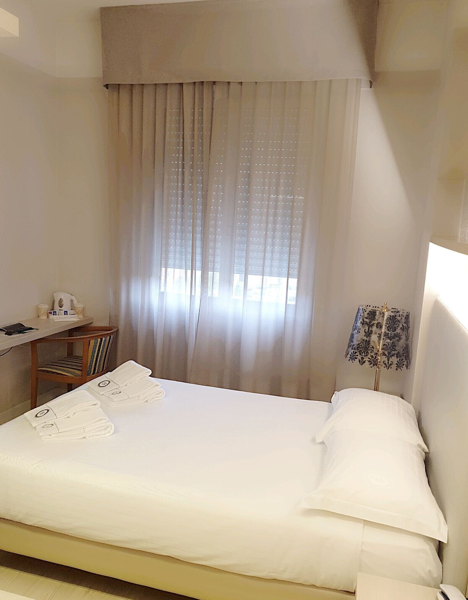 Ein Hotelzimmer mit Bett, Schreibtisch und Stuhl.