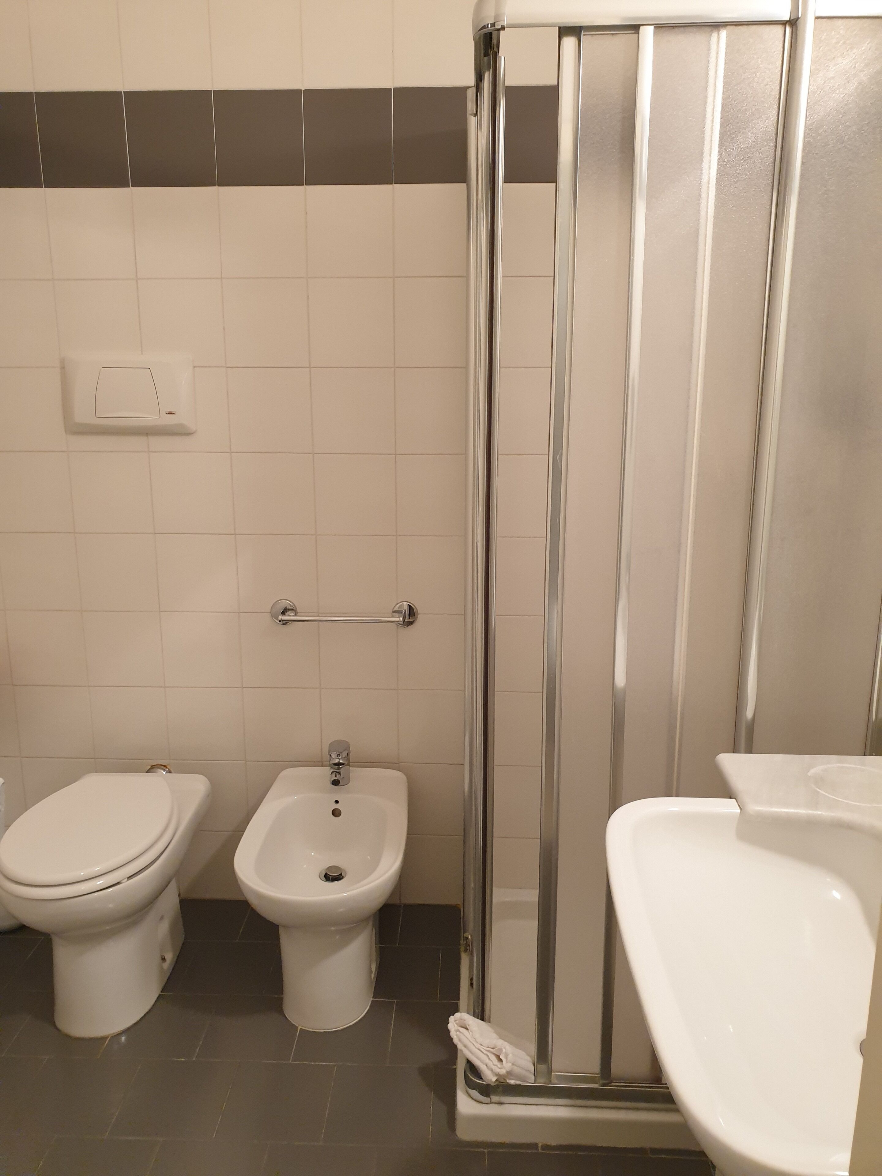 A bathroom with a toilet, bidet, and shower stall.