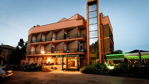 A hotel with a modern architectural design, featuring multiple balconies and a prominent vertical glass tower. - Hotel Augustus (Fano)