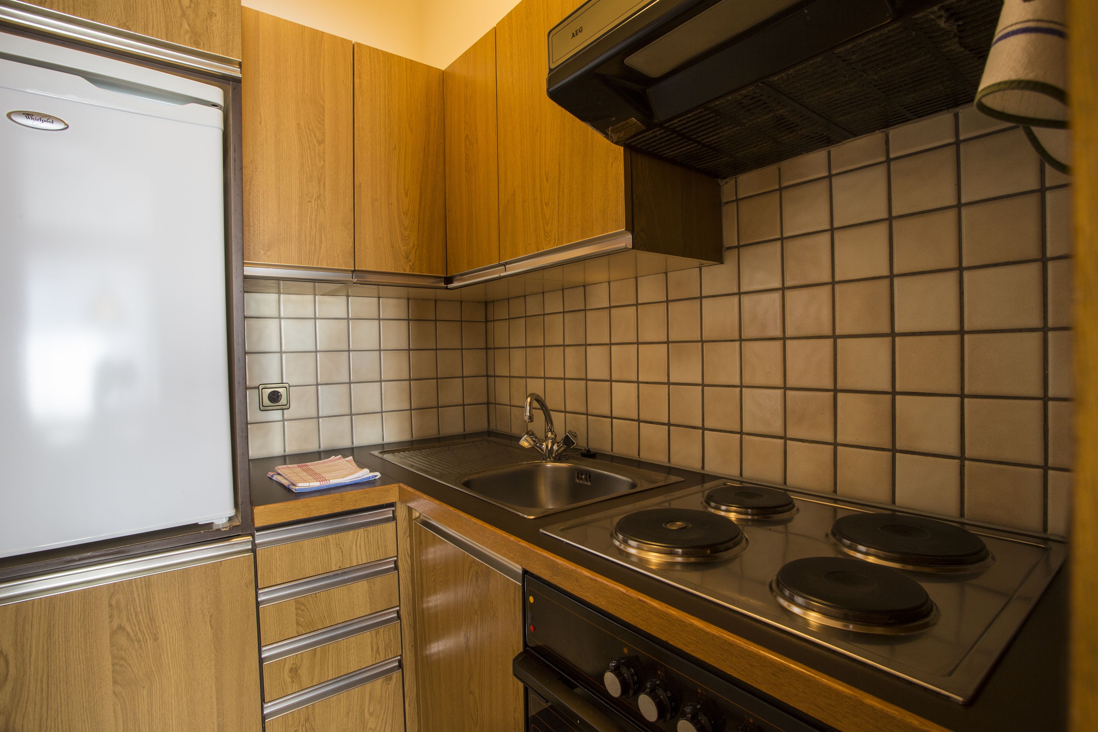 A kitchen with wooden cabinets, a stainless steel sink, and a gas stove.