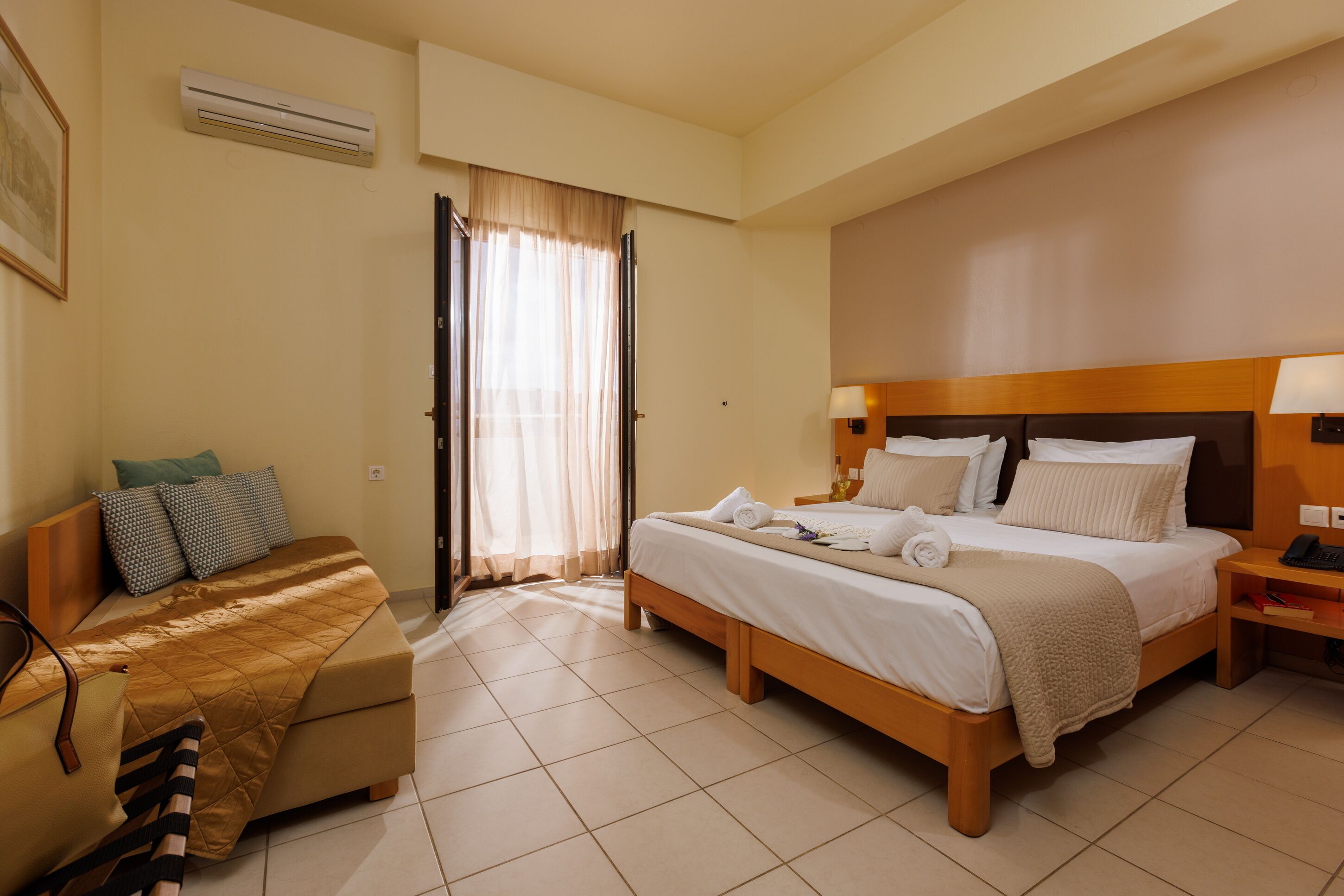 Habitación de hotel con cama, escritorio, silla y ventana con cortinas.