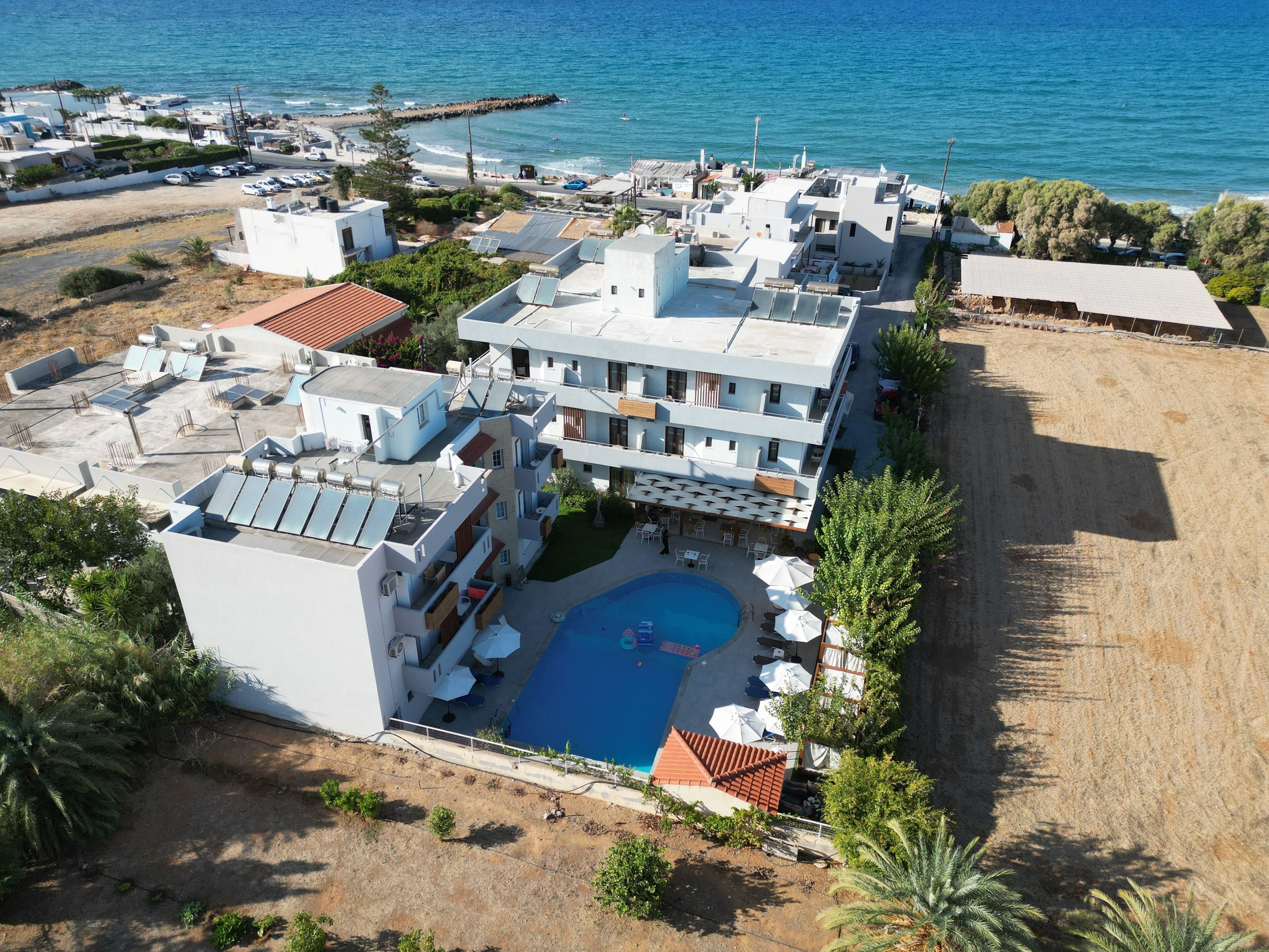 Un hôtel en bord de mer doté d’une piscine sur le toit, de plusieurs balcons et offrant une vue sur la mer.