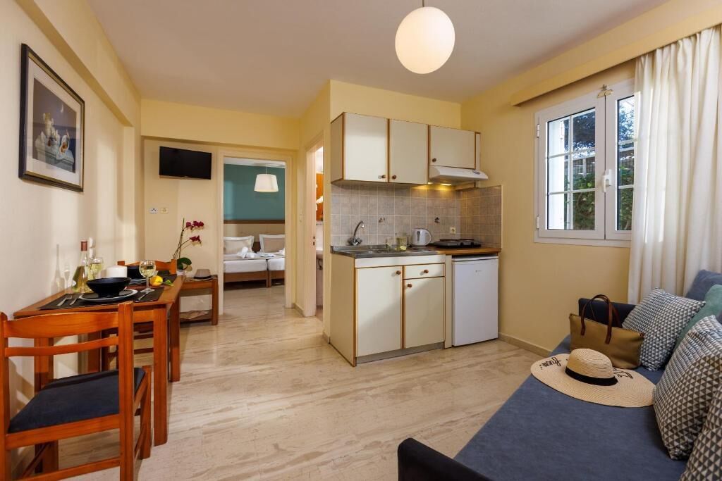 A compact living space with a dining area, kitchenette, and a sofa with a view.