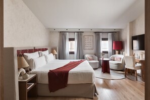 Una habitación de hotel moderna con una cama grande, un escritorio, una silla y un televisor.