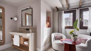 Un baño moderno con un espejo grande, un lavamanos y dos sillas.