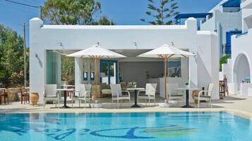 Alberca al aire libre, sombrillas en la alberca y camastros