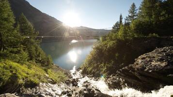 A mountainous landscape with a clear lake, a bridge, and dense forest.