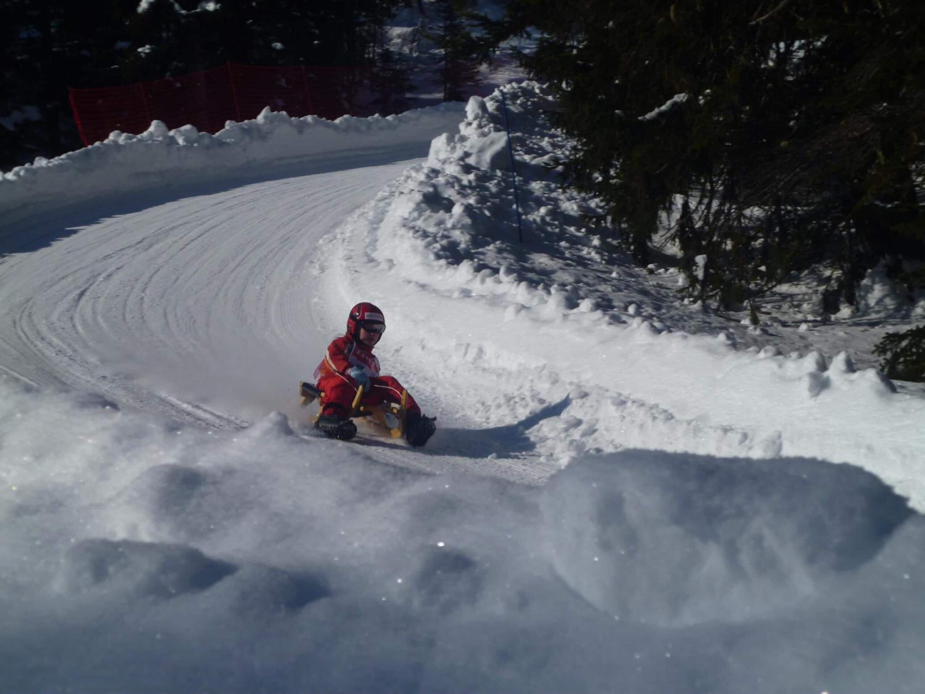 A person sledding down a snowy slope.