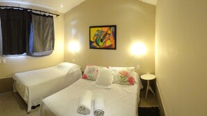 A hotel room with two beds, a painting on the wall, and a small round table. - Albergaria Hostel & Bar (Fortaleza)