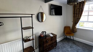 A bedroom with a bunk bed, a dresser, a mirror, a TV, and a window with curtains. - Elephant & Castle (Holmfirth)