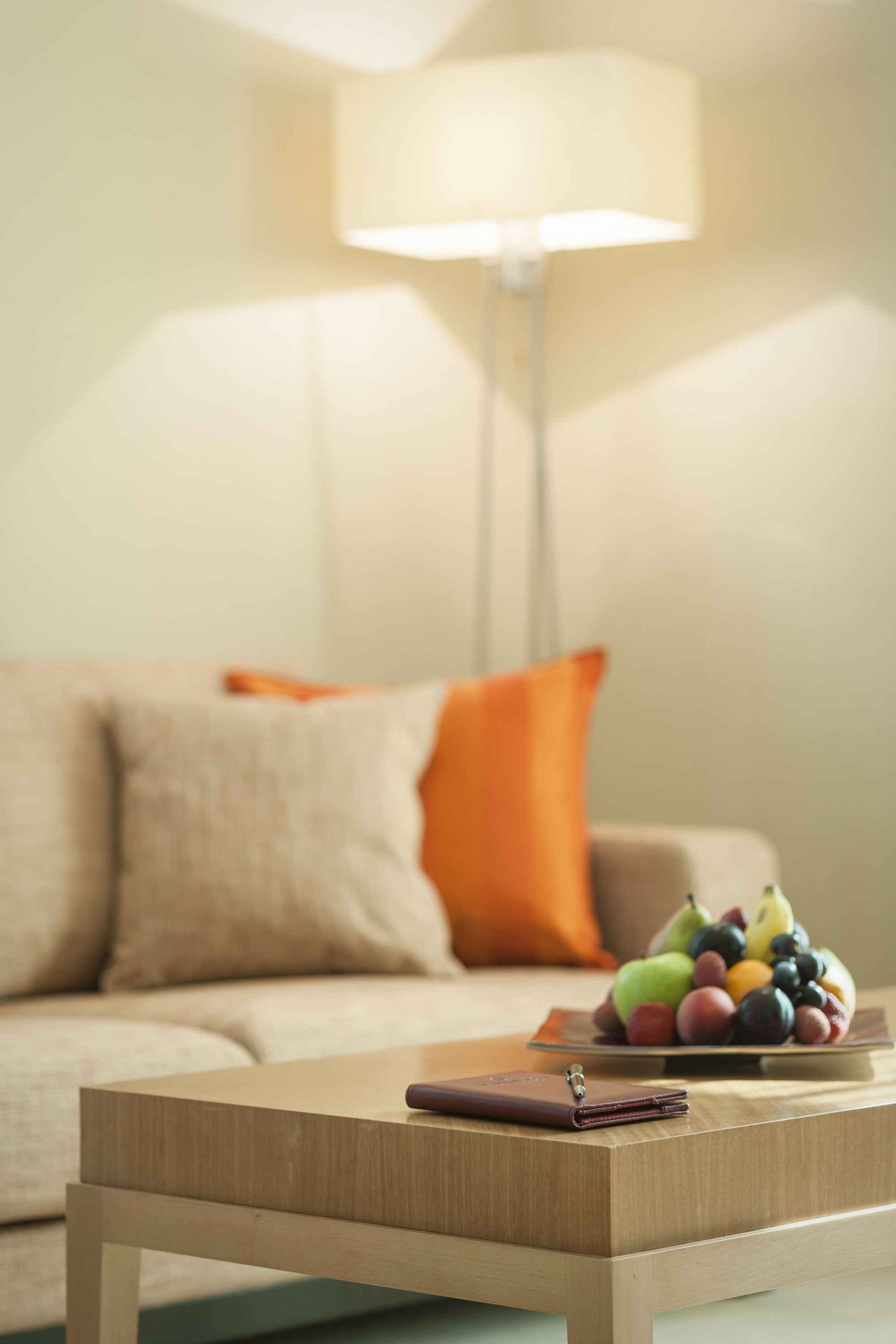 A wooden coffee table with a wallet and a fruit bowl.