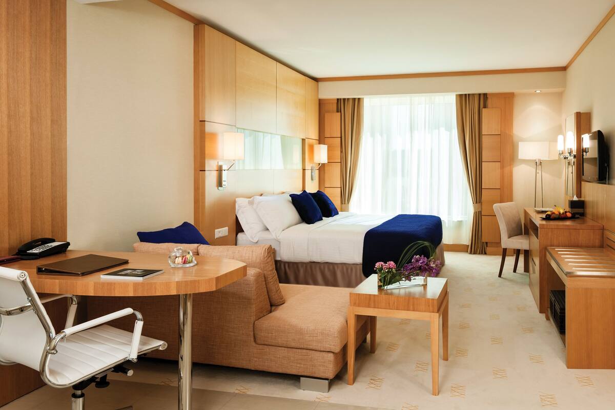 Une chambre d’hôtel équipée d’un lit, d’un bureau, d’une chaise et d’une télévision.