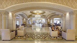 A spacious lobby with ornate arches, a chandelier, and seating areas. - Royal Alhambra Palace – All Inclusive (Manavgat)